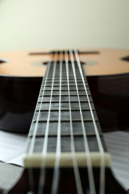 Classical guitar and music sheet, close up and selective focus