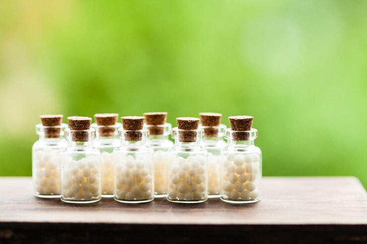 Photo classical homeopathy globules in vintage bottles and nature leaves