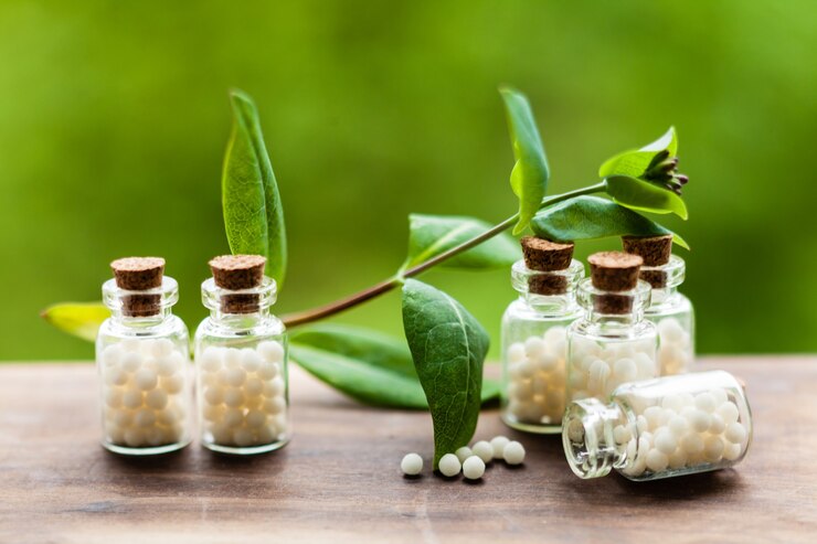 Photo classical homeopathy globules in vintage bottles and nature leaves