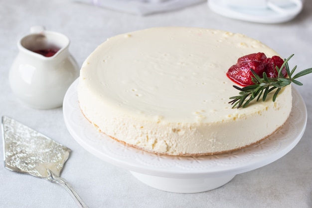 Classical New York cheesecake with strawberry sauce and rosemary