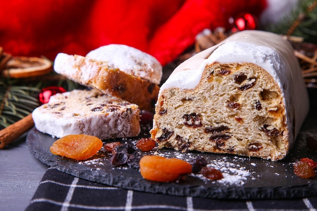 Classical stollen on dark background. Traditional Christmas festive pastry dessert. Stollen for Christmas