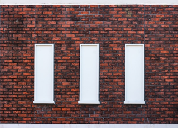 Classical vintage design window on weathered red brick blocks wall background.