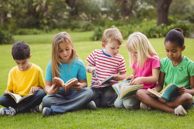 Classmates sitting in grass and reading books