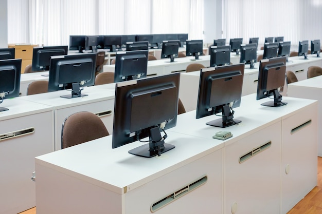 Classroom computers. Empty no people with many monitor computer on white desk.