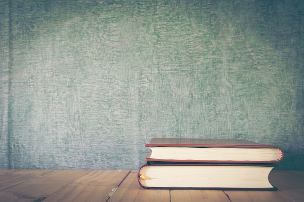 Foto aula con lavagna, tavolo in legno e libri