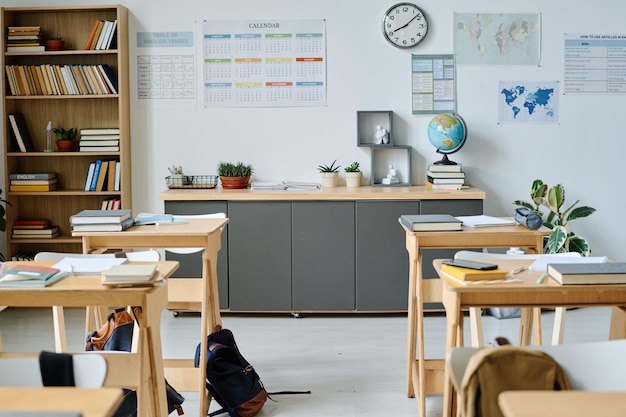 Photo classroom with desks and book on them in elementary school