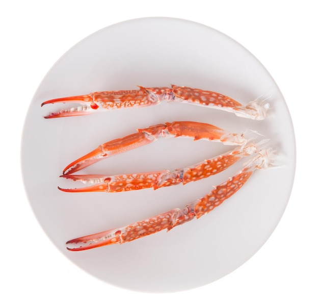 Photo claw of crab prepared on plate isolated on white background