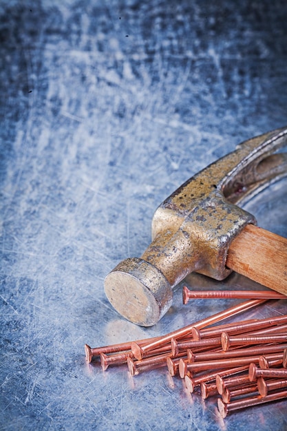 Claw hammer brass construction nails on metallic background