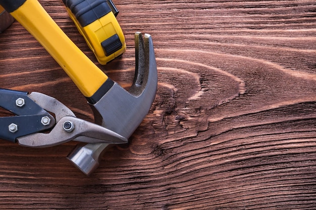 Claw hammer nippers and tapemeasure on wood board construction concept