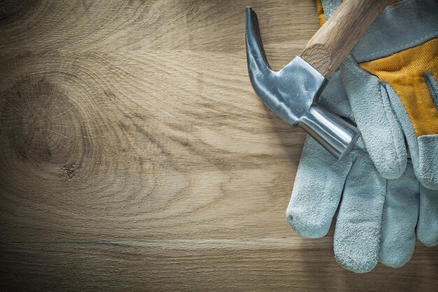 Claw hammer pair of protective gloves on wooden board