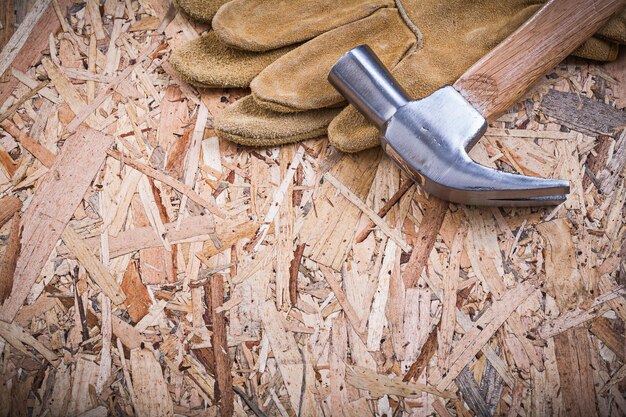 Photo claw hammer pair of safety gloves on chipboard