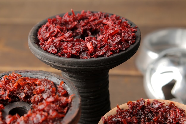 Clay bowls for hookah with tobacco on a brown wooden table. accessories for hookah. close-up