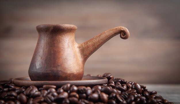 Clay coffee pot on coffee beans