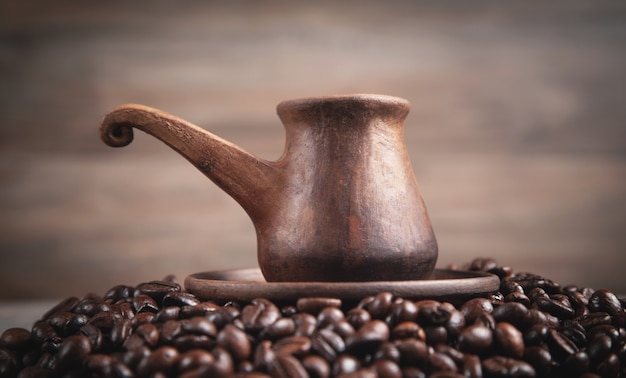 Clay coffee pot on coffee beans.