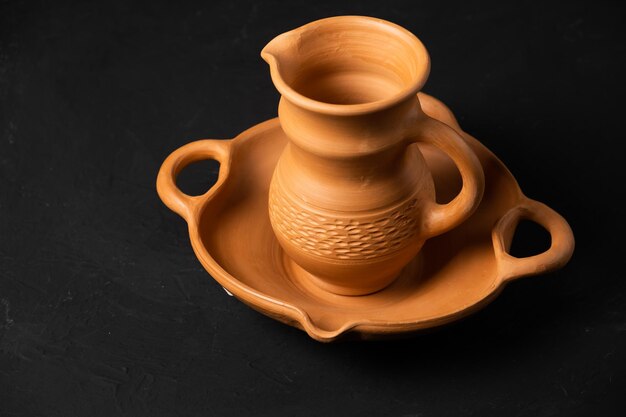 Clay cup and saucer isolated on black background
