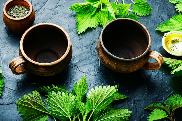 Clay cups with nettle herbal tea.Herbal medicine,homeopathy