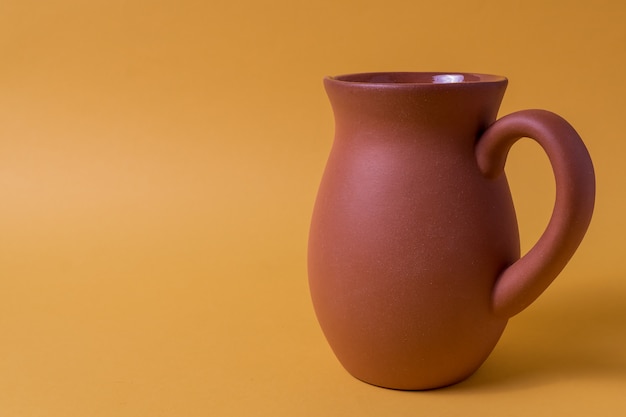 Clay Jug on yellow background and copy space for text.