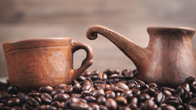 Clay koffiekopje en pot op koffiebonen.