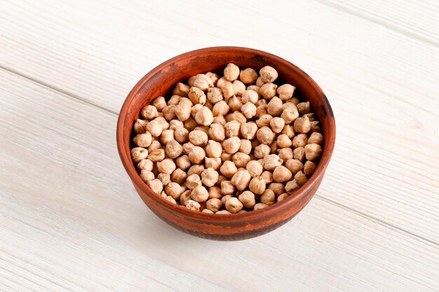 clay plate with chickpeas on a light wooden table