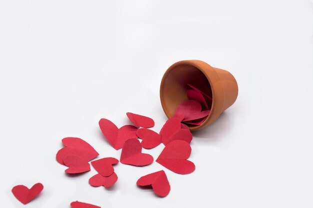clay pot and red hearts around the pot  on white background
