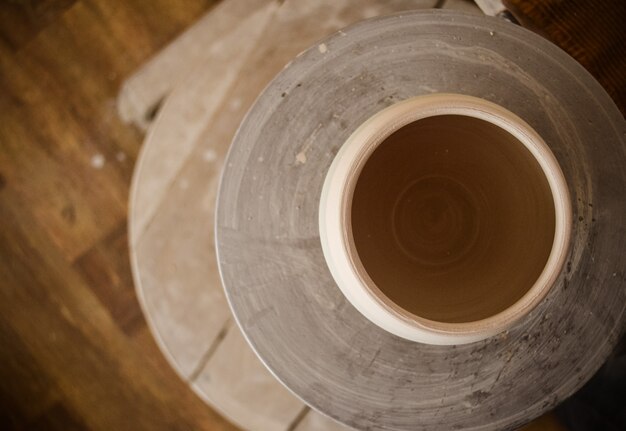 Clay pot on top of a potter's wheel. Abstract top view of a ceramic pot