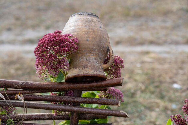 Clay pot on wicker fence outdoors Ukraine Rural ukrainian national style