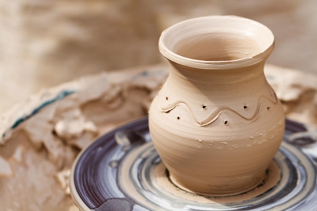 Clay pot with pattern on a pottery wheel