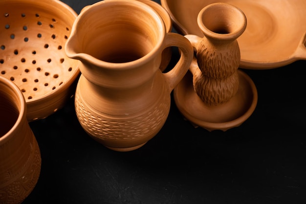 Clay pots for cooking light clay clay pots baking tins on a\
dark background earthenware colander plate grocery candlestick\
vintage kitchen utensils for cooking