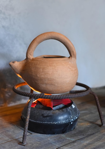 Photo clay teapot on artificial hearth