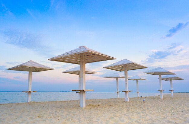 Clean beach with wooden umbrellas, And the blue evening sky