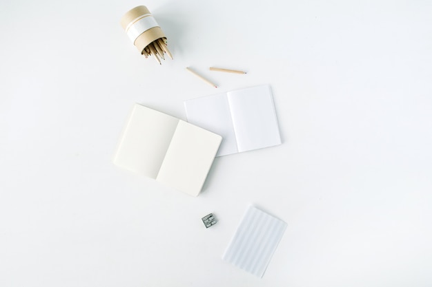 Clean blank sketchbook, pencils and pencil sharpener on white