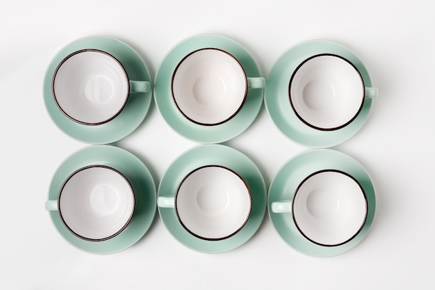 Clean dishes, coffee or tea set. Plenty of elegant porcelain cups and saucers, high key, top view and flat lay.