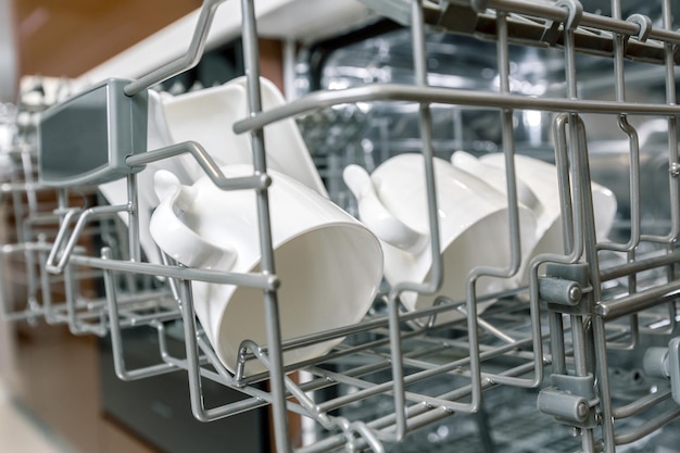 Чистая посуда в открытой посудомоечной машине