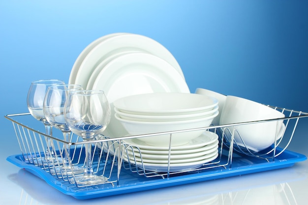 Clean dishes on stand on blue background