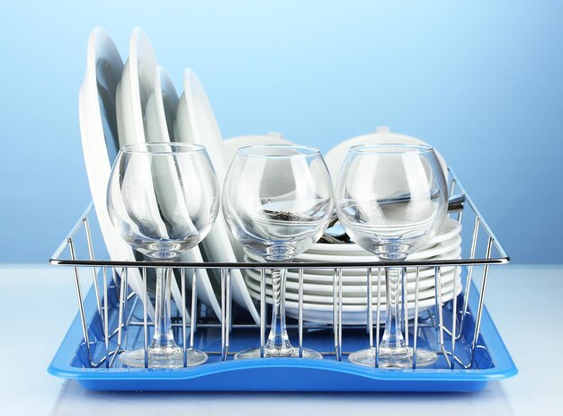 Clean dishes on stand on blue background