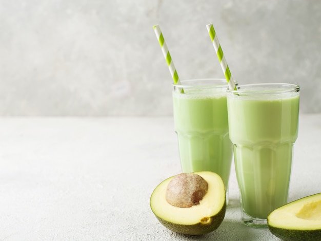 Clean eating. Avocado smoothie in glass over white background