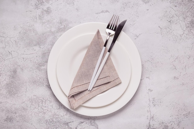 Clean empty white plate with cutlery