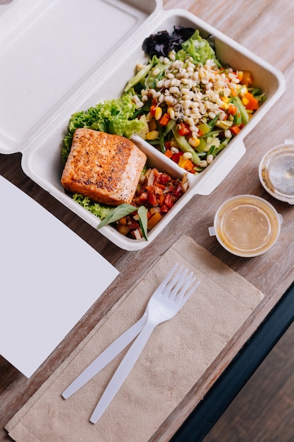 Clean food meal box: Grilled salmon fillet with tomato and bean sprout salad.