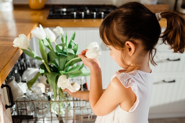 Clean kitchen concept White tulips flowers standing in dishwasher