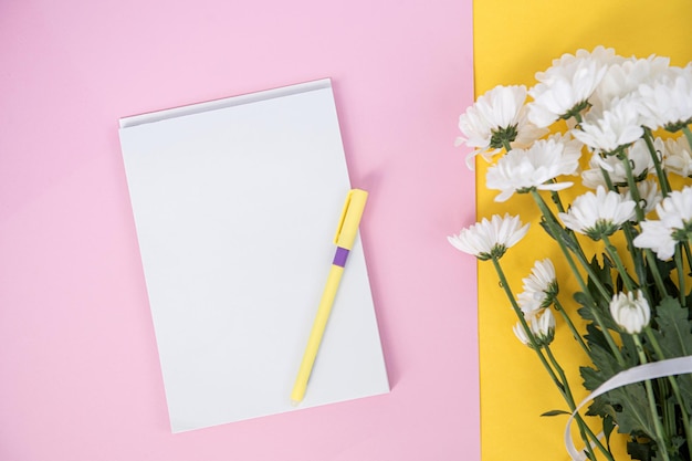 A clean notebook and pen on a light pink table