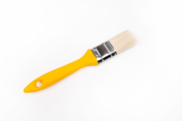 Clean paint brush with yellow handle on a white background. Build a house