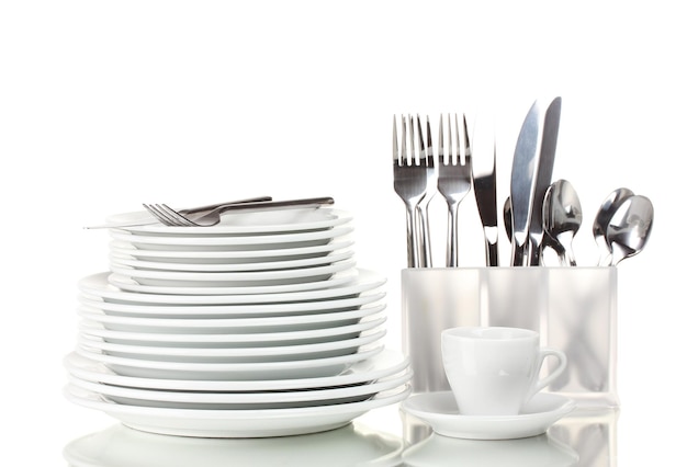Чистые тарелки и столовые приборы, изолированные на белом