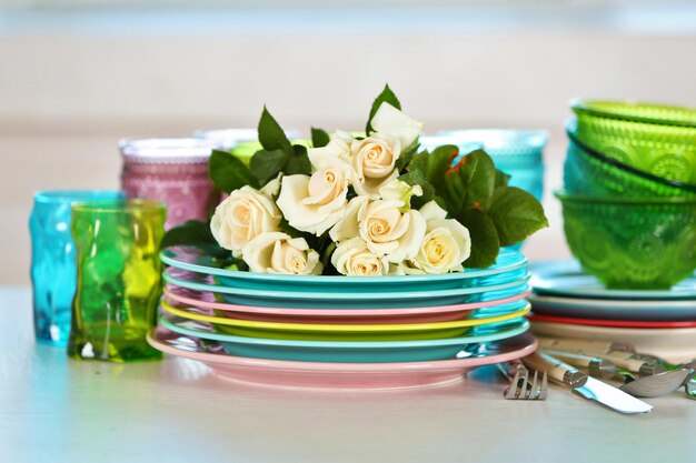 Clean plates glasses and cutlery on white table