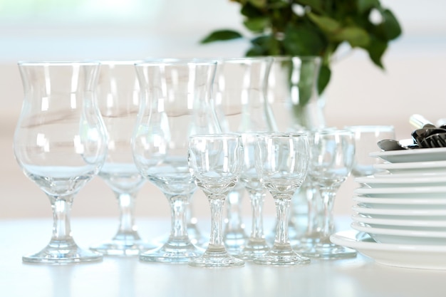 Clean plates, glasses and cutlery on white table