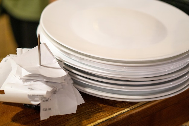 Clean plates stand on a wooden bar near the checks