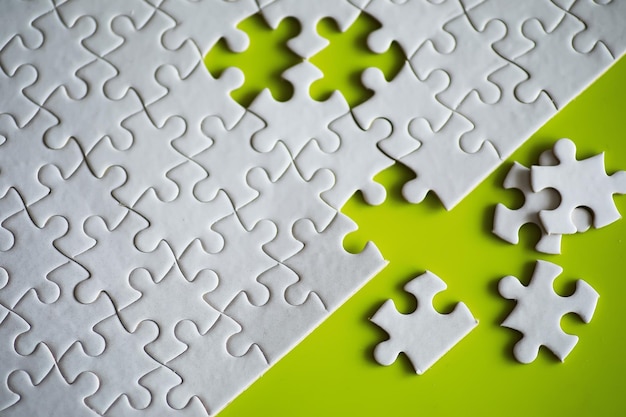 Foto elementi di puzzle puliti sullo sfondo pezzo di puzzle vuoto sul tavolo concetto di lavoro di squadra