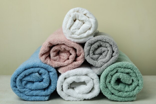 Asciugamani rotolati puliti contro il beige, da vicino