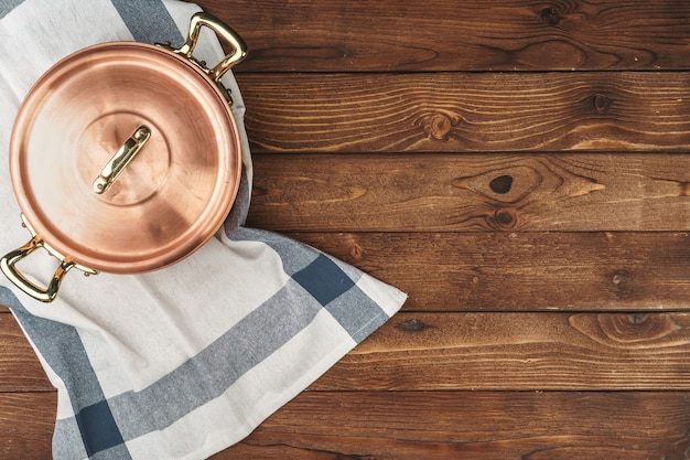 Clean shiny copper kitchenware on wooden board