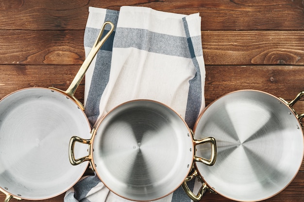 Clean shiny copper kitchenware on wooden board