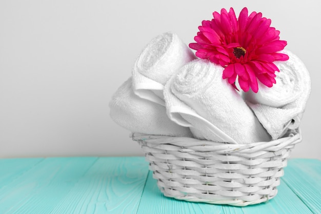 Фото Чистые мягкие полотенца с цветком на деревянном столе